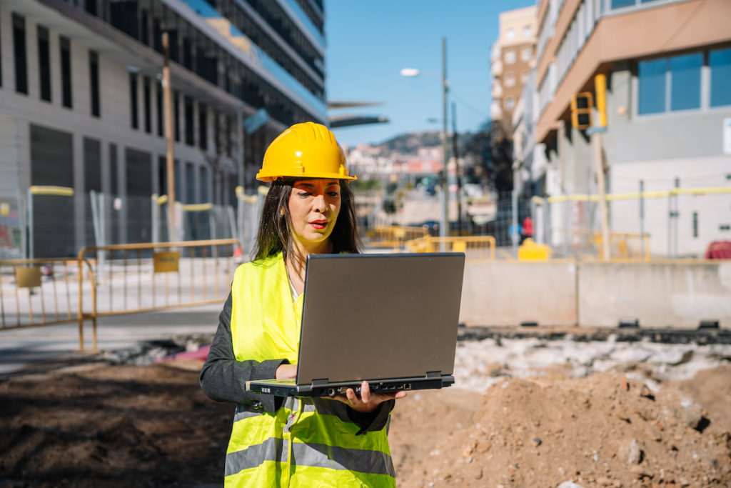 inspector using laptop at construction site