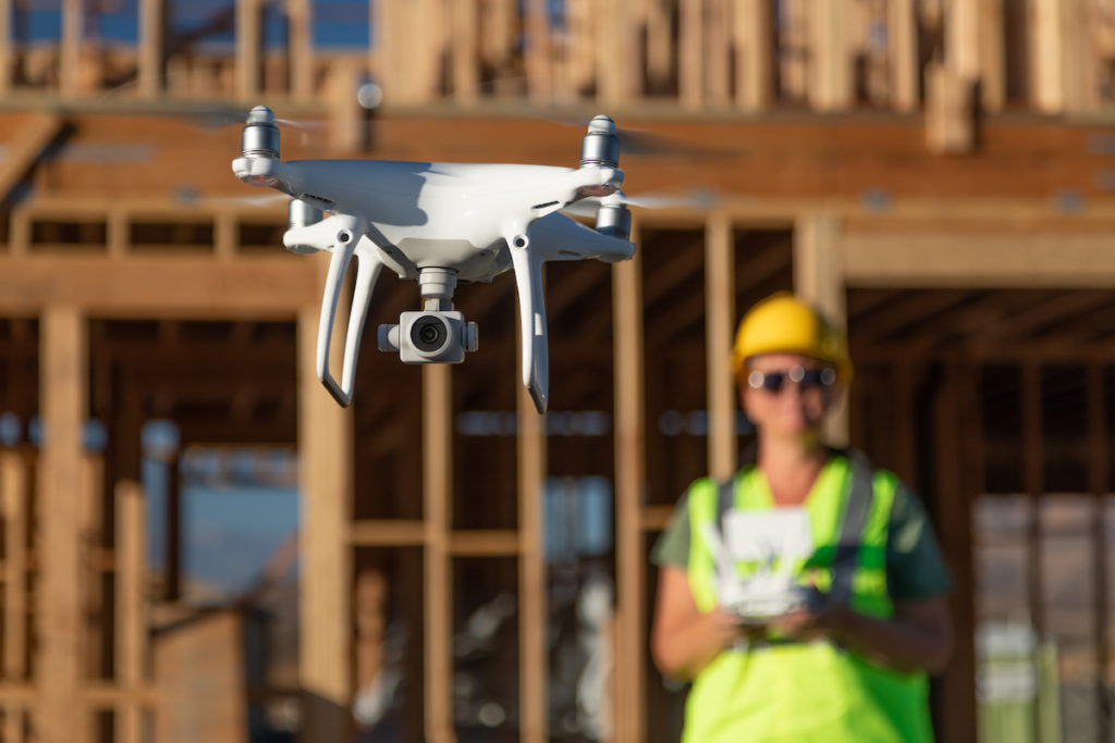 Female Pilot Flies Drone Quadcopter Inspecting Construction Site.